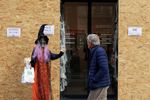 暴動対策の板が張られた店頭の、ハロウィーンのデコレーション